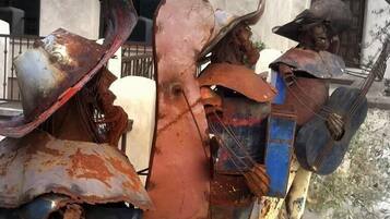 Una escultura de un toro con jinete, hecha de metal oxidado, en un entorno exterior.