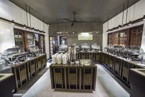 A buffet setup with multiple serving stations, a central island with bowls, and a ceiling fan. - Kithala Resort (Thissamaharama)