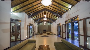 A spacious lobby with high ceilings, a central seating area, and large windows providing natural light. - Kithala Resort (Thissamaharama)