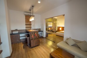 A modern kitchen with wooden cabinets, a central island, and a built-in wine rack. - Kithala Resort (Thissamaharama)