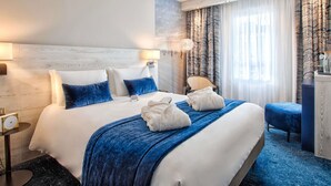 A hotel room with a large bed, a bedside table, a lamp, a chair, and a view of the outside through the window. - Mercure Trouville-sur-mer (Trouville-sur-Mer)