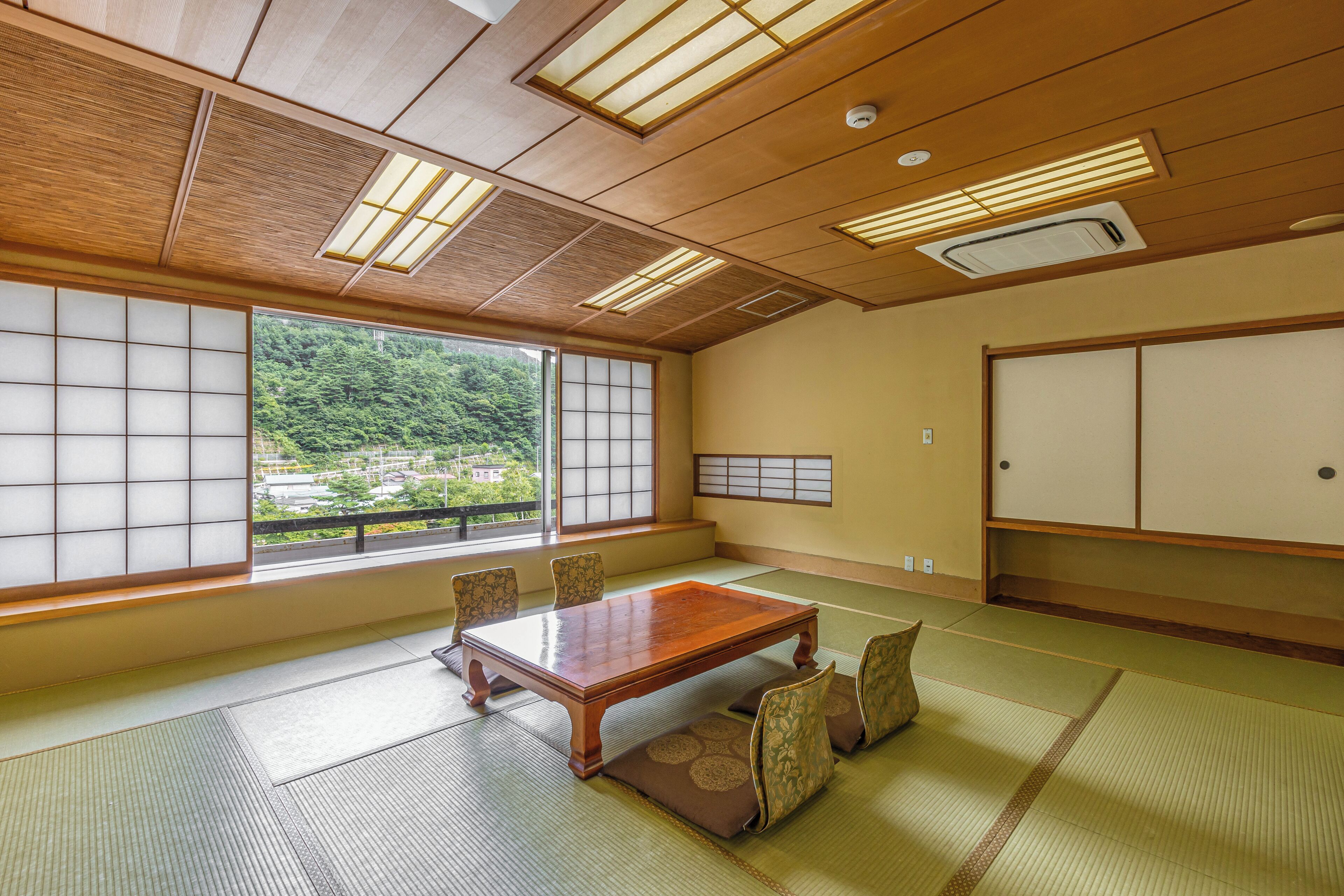 Une pièce de style japonais traditionnel, avec un sol recouvert de tatamis, une basse table en bois et des paravents en papier de riz (shoji).