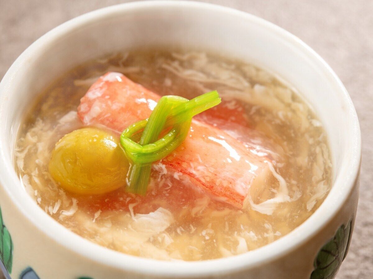 Un bol de soupe avec un bouillon clair, contenant des morceaux de viande et des légumes.