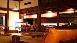 A traditional Japanese-style room with tatami flooring, low wooden tables, and chairs. - Yumoto Saito Ryokan (Matsumoto)