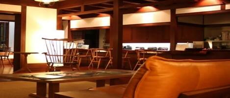 Una habitación al estilo tradicional japonés, con suelo de tatami, mesas de madera bajas y sillas.