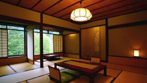 A traditional Japanese room with tatami flooring, a low wooden table, and sliding doors. - Yumoto Saito Ryokan (Matsumoto)