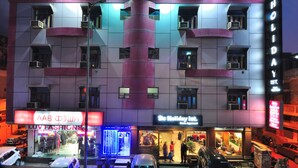 A multi-story building with a modern design, featuring a prominent 'De Holiday Inn' sign. - Hotel De Holiday International (New Delhi)