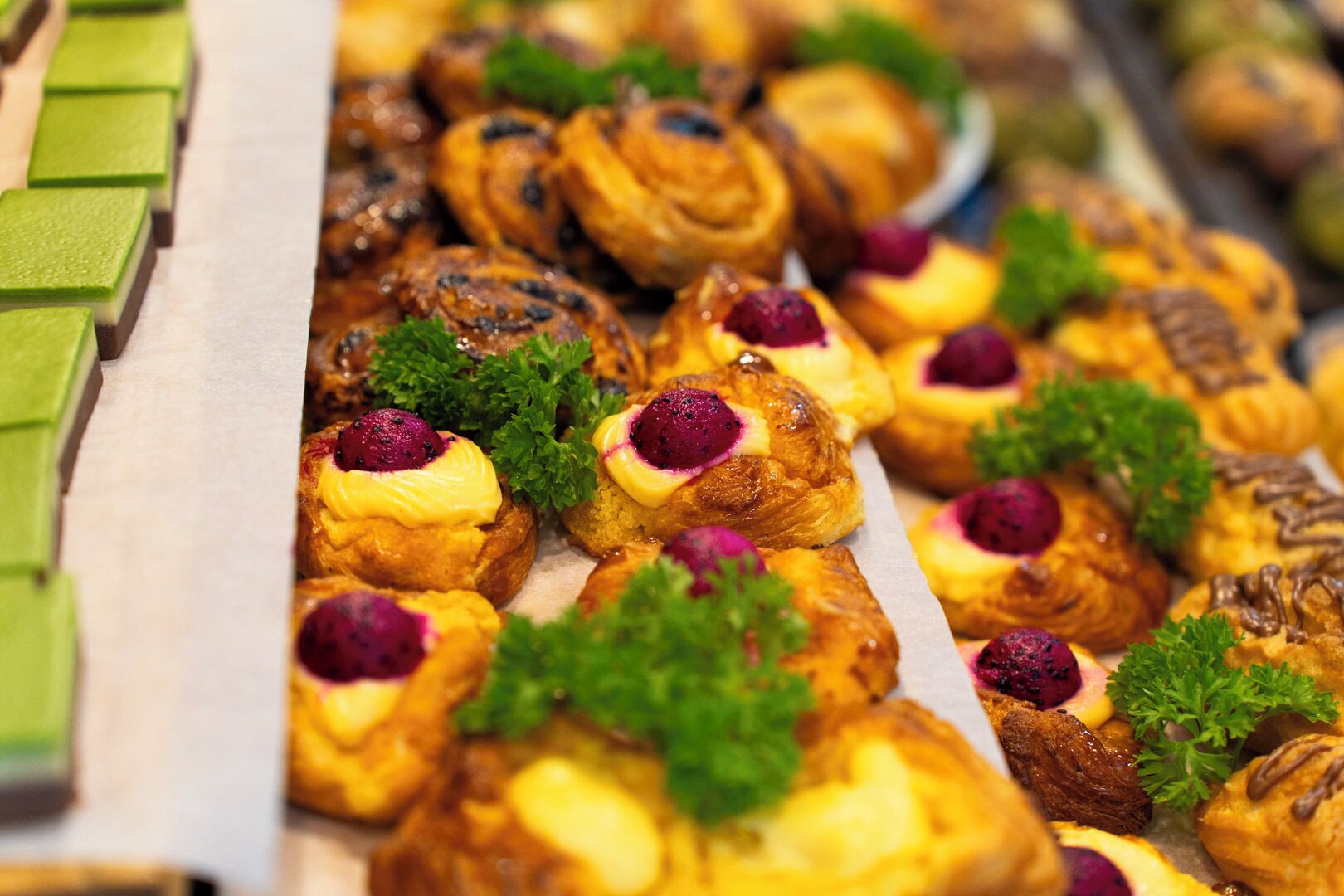 A variety of pastries, including croissants and muffins, arranged on a tray.
