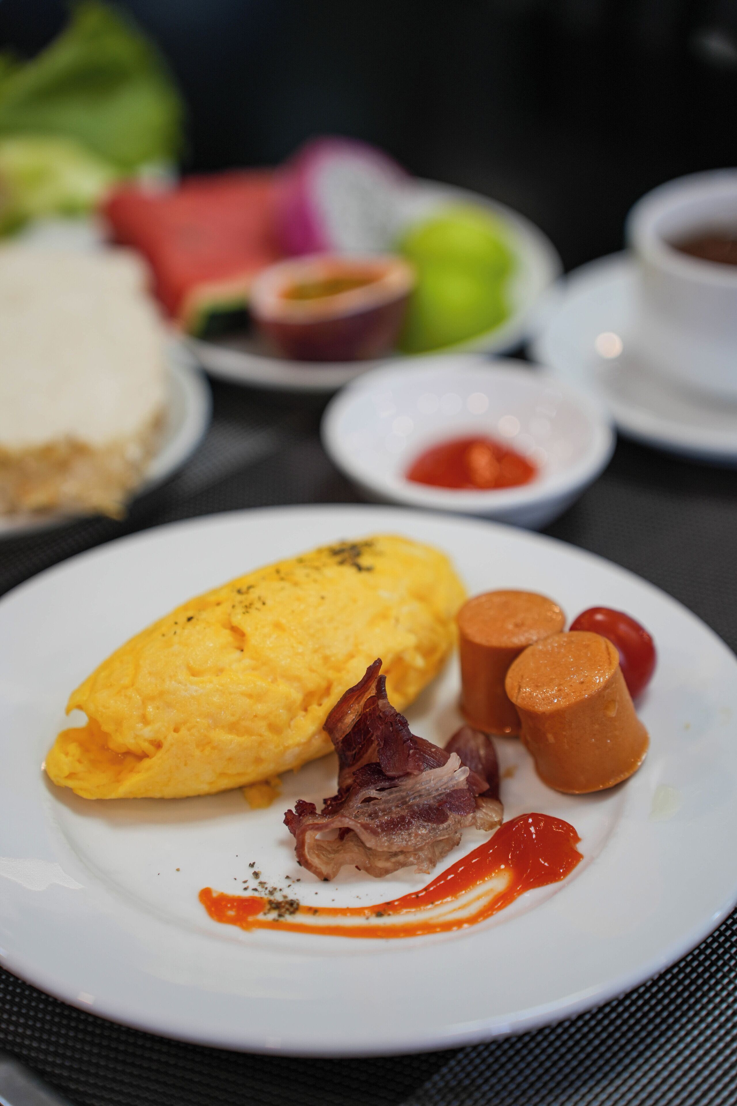 Un plato con una tortilla, tocino y kétchup.