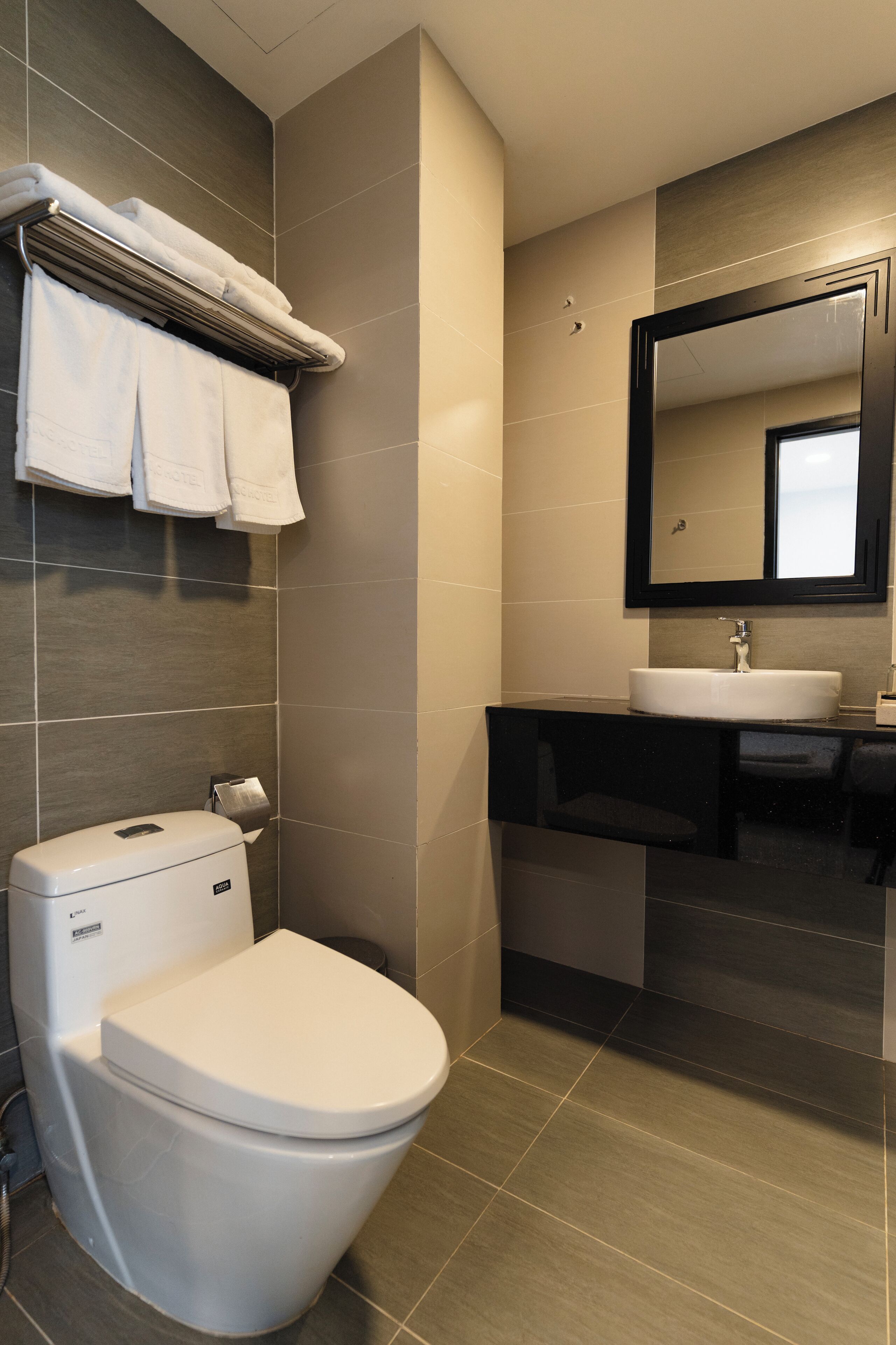 Et moderne badeværelse med toilet, vask og spejl.