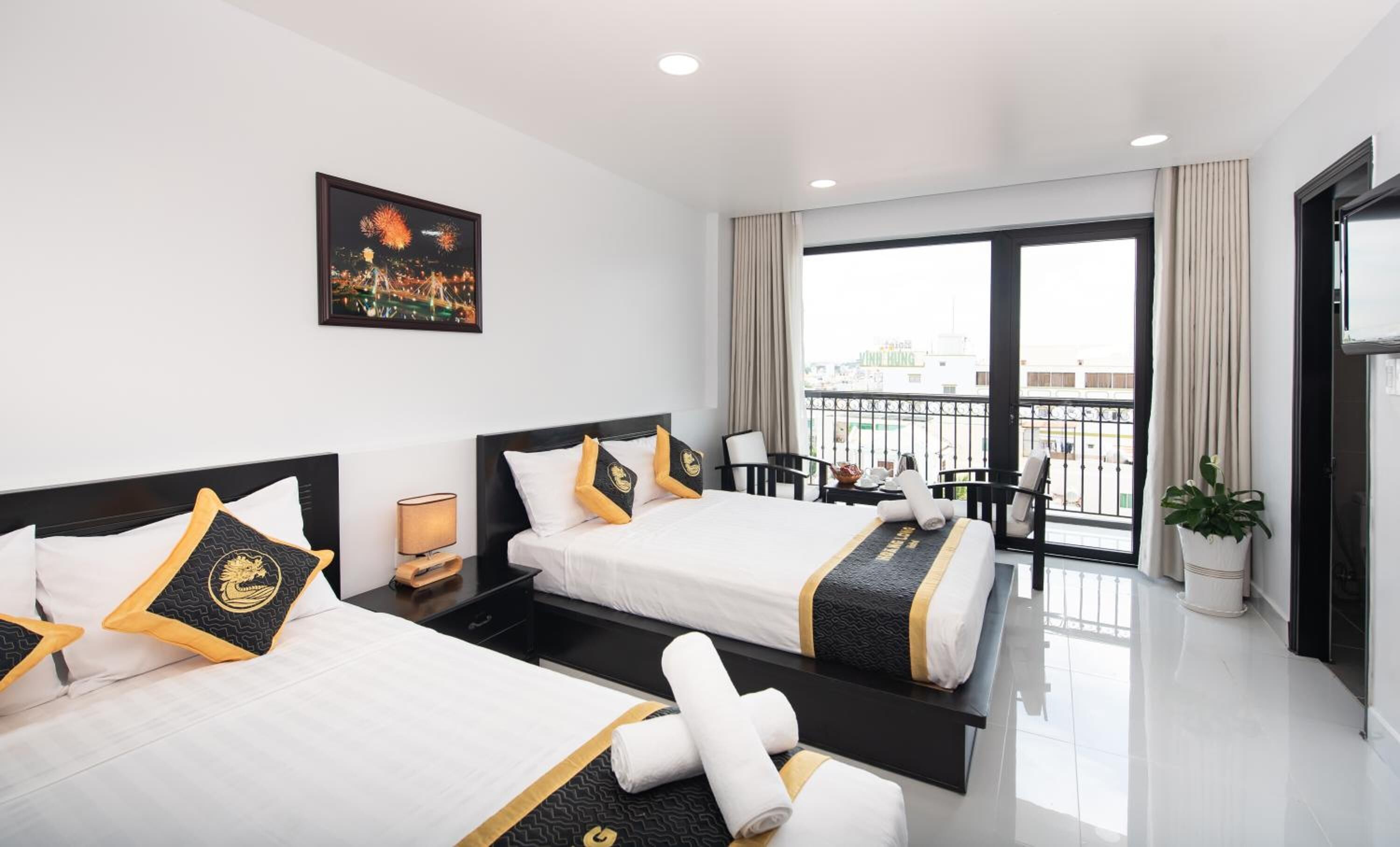 Une chambre d’hôtel avec deux lits, un balcon et une vue sur la ville.