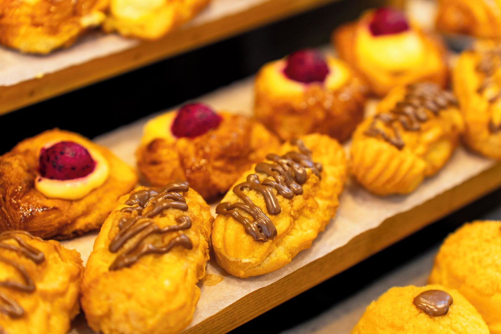 A display of pastries on a wooden shelf.