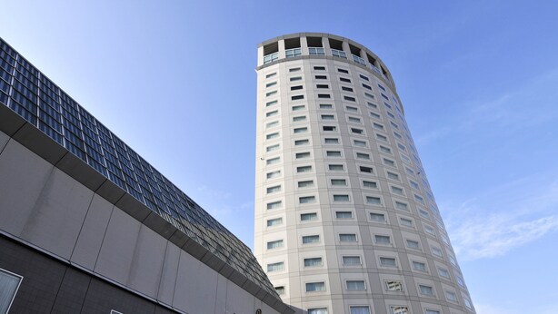 Ein hohes Hotelgebäude mit modernem Design, das eine geschwungene Fassade und viele Fenster aufweist.