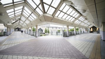 A spacious indoor area with a high ceiling and skylights, featuring a tiled floor and a central walkway.