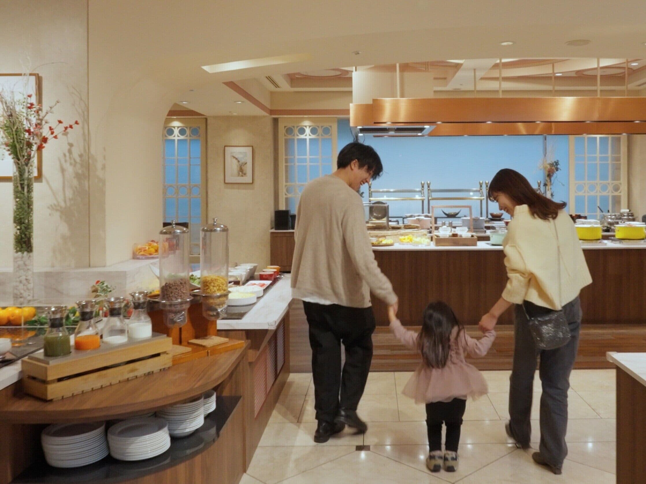 A modern kitchen with a buffet setup, featuring a variety of food items and a decorative plant.