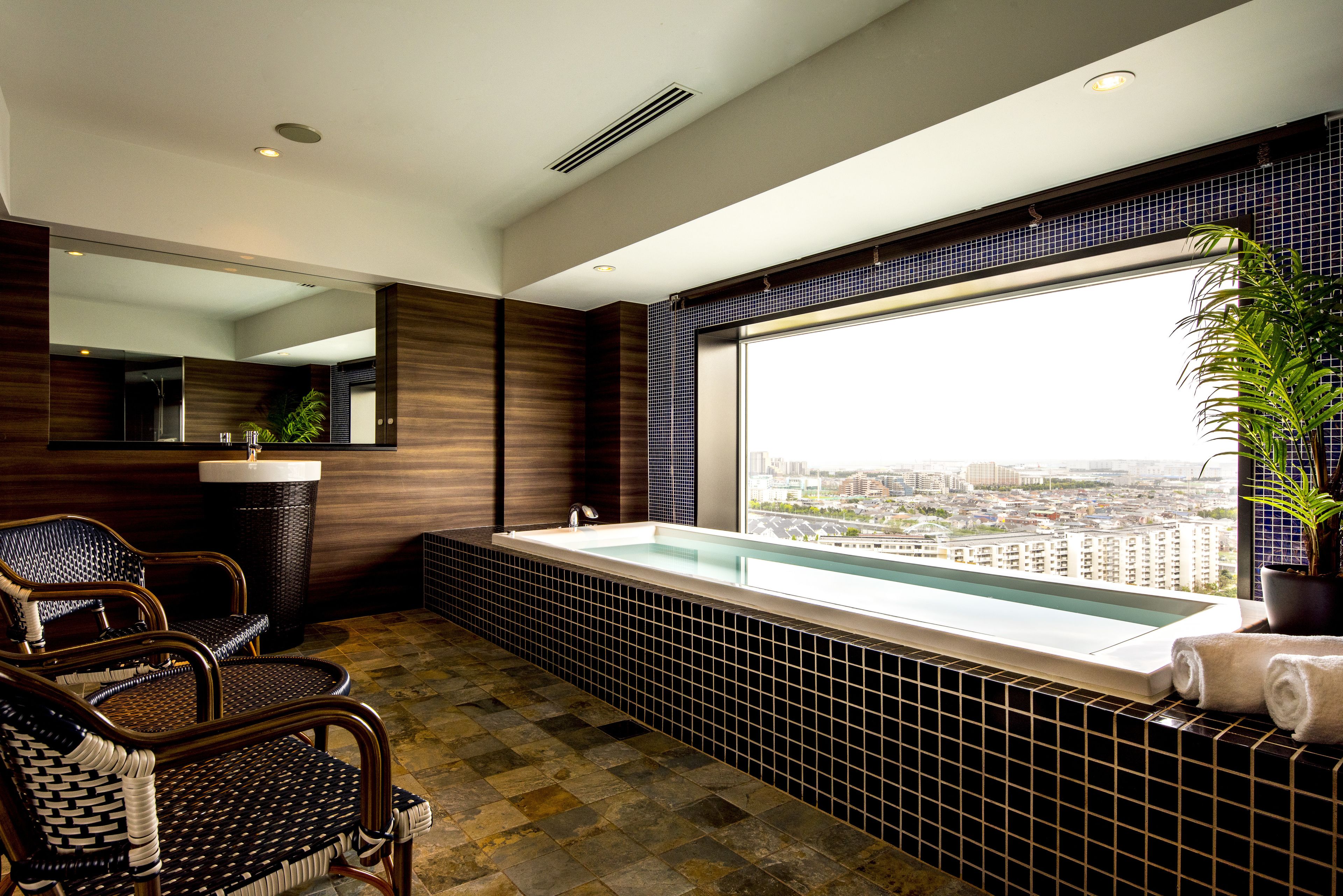 Un baño moderno con una bañera grande, un lavabo y una silla.