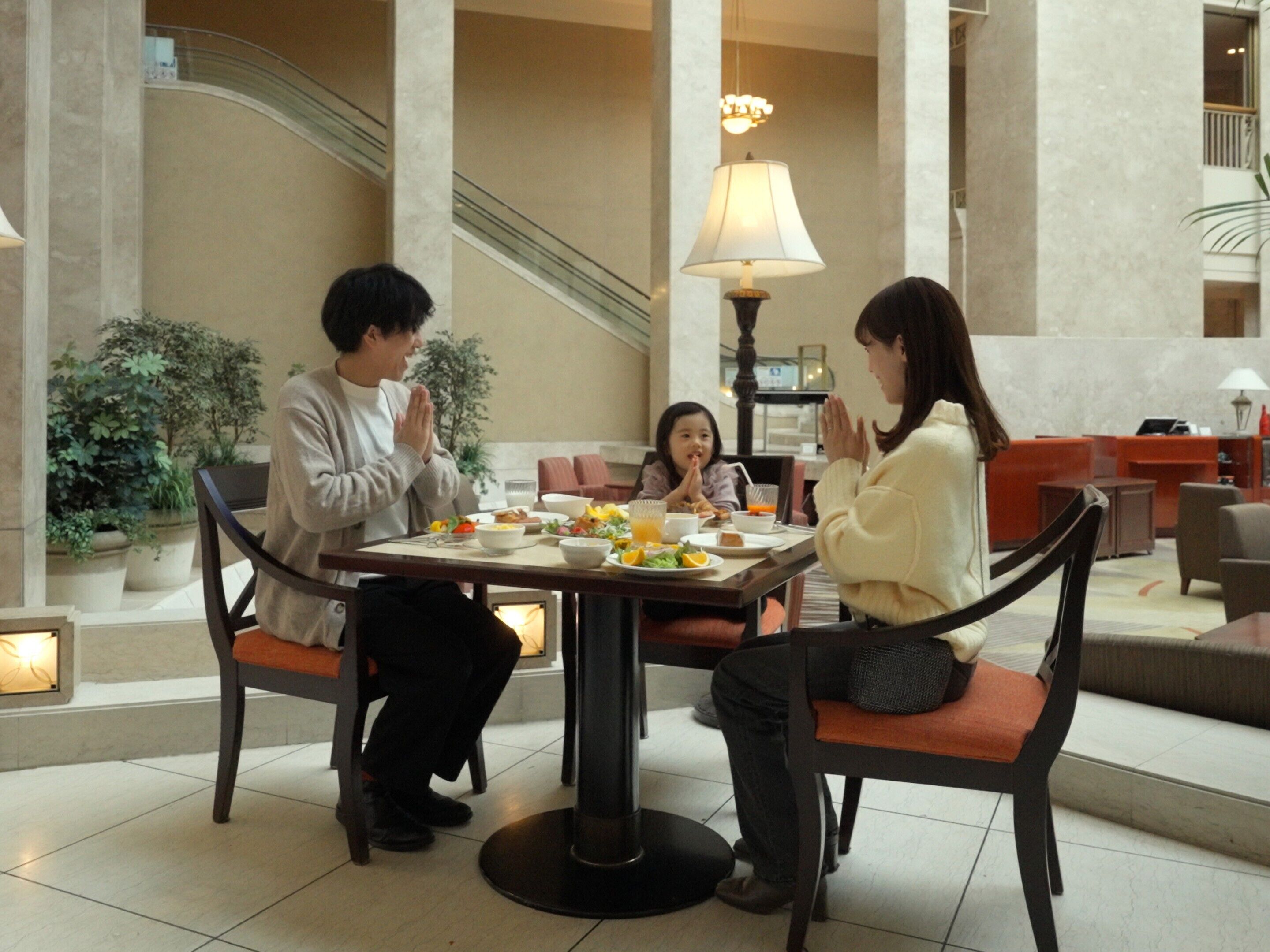 A dining area with a table set for three people, surrounded by chairs.