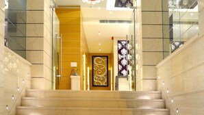 A grand staircase leading to a hotel lobby with a sign reading "Hotel Saurer Grand". - Sawera Grand (Amritsar)