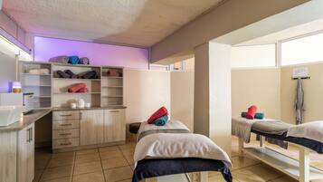 Comfortable room with two single beds, a seating area, and a shelf unit.