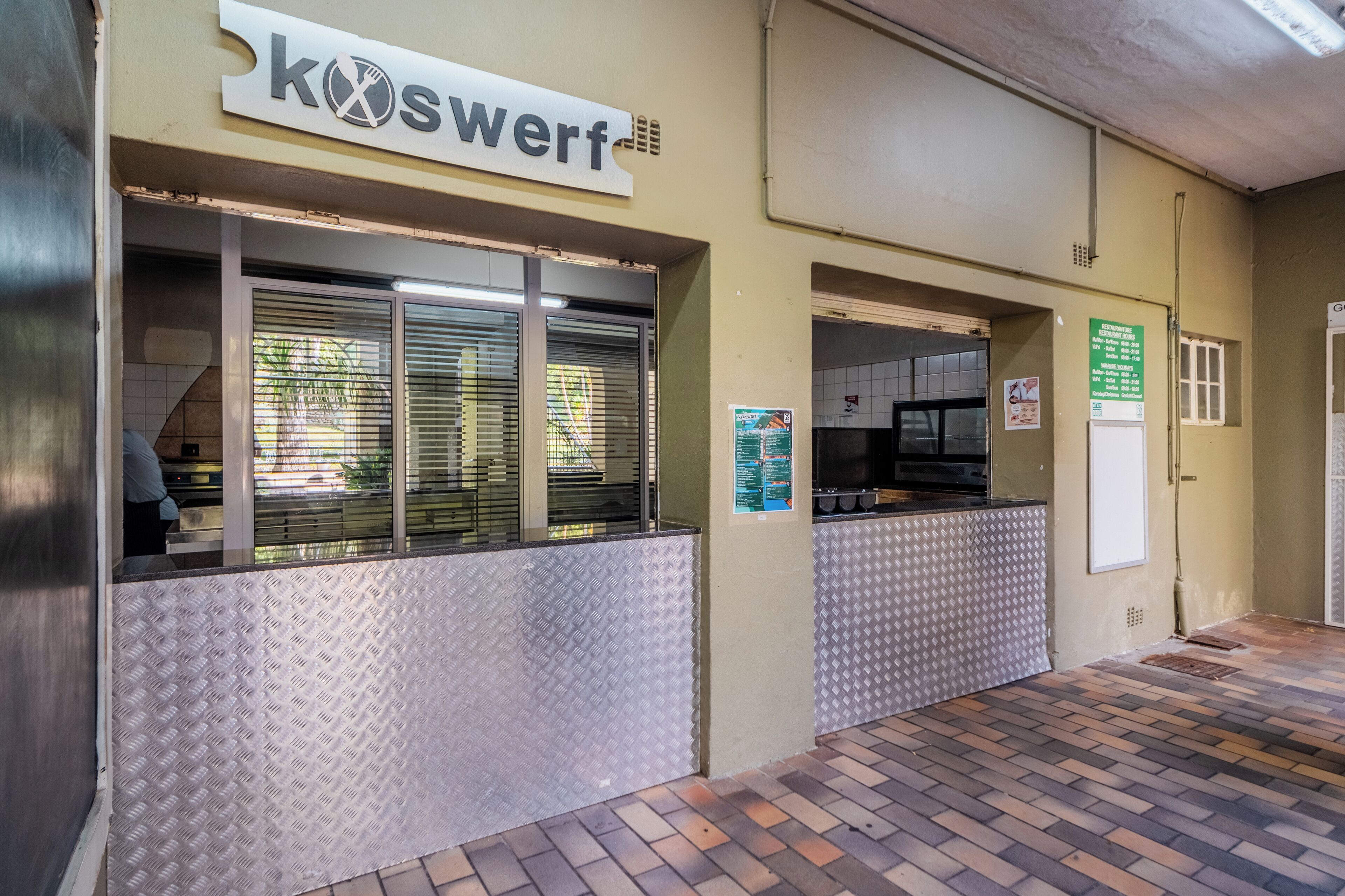 A commercial kitchen with a sign reading "kOSWERF".