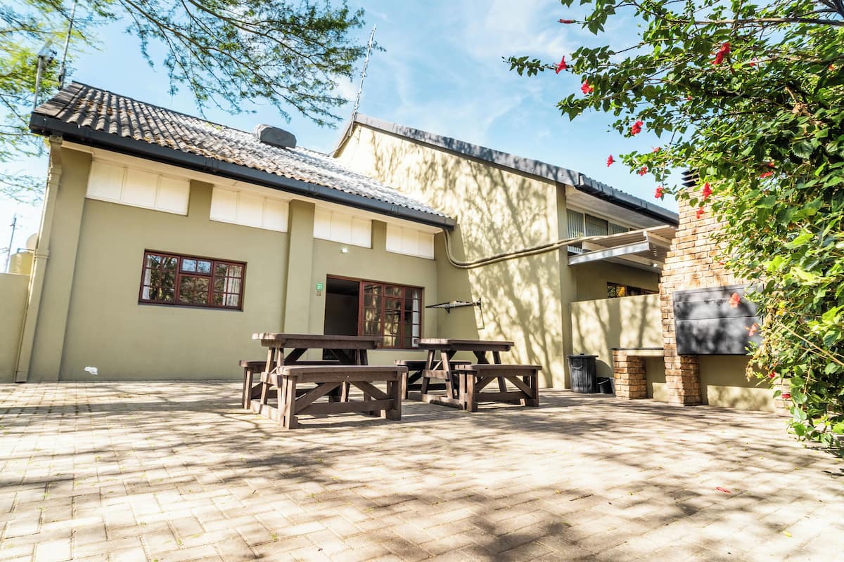 A building with a tiled roof, wooden benches, and a brick wall.