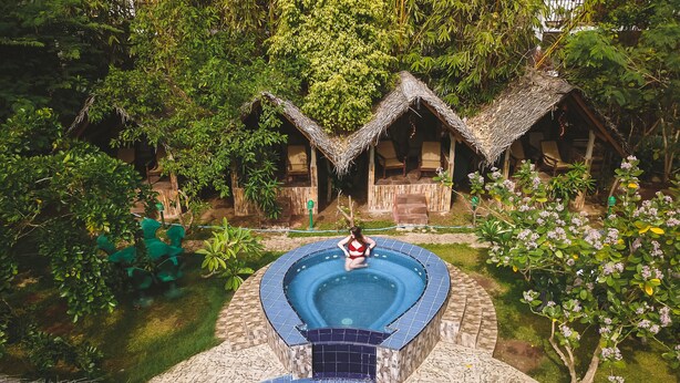 A circular pool with a tiled edge, surrounded by a stone pathway and lush greenery. - Sundaras Resort & Spa (Dambulla)