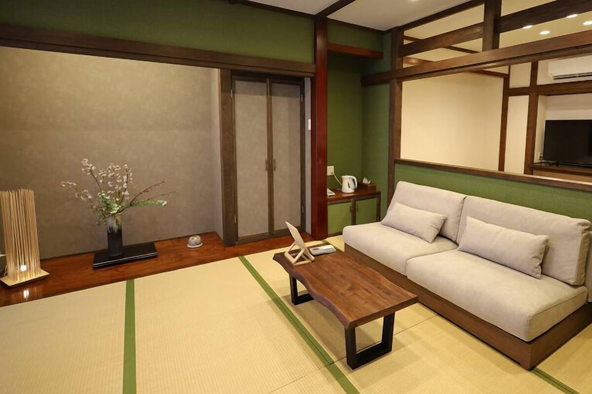A living room with a sofa, a coffee table, a TV, and a sliding door.