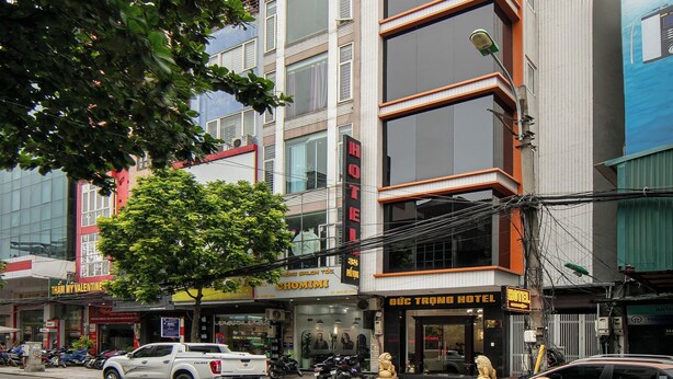 Un hôtel à plusieurs étages, doté d’une façade moderne, situé dans un environnement urbain, entouré d’autres bâtiments.