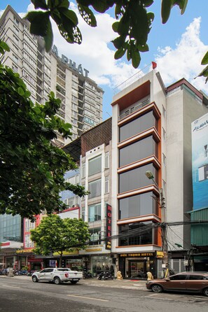 Un hôtel à plusieurs étages, doté d’une façade moderne, situé dans un environnement urbain, entouré d’autres bâtiments.