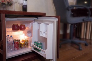 Un réfrigérateur contenant des pommes, des boissons et des conserves.