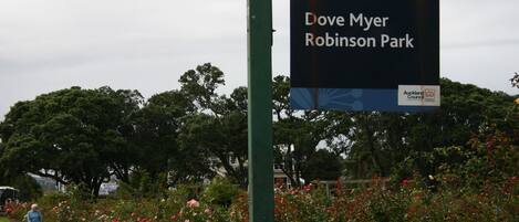 A sign for Dove Myer Robinson Park with a green post and a logo for Auckland Council.
