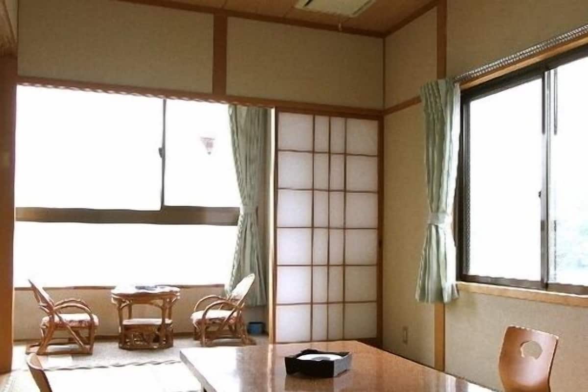 A traditional Japanese room with tatami flooring, a low table, and a shoji screen.
