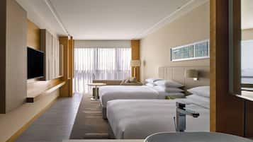 Een hotelkamer met twee bedden, een televisie, een bureau en een raam met gordijnen.