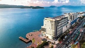 Un hotel moderno con vista al agua, que cuenta con un edificio grande de varios pisos y un estacionamiento junto al agua.
