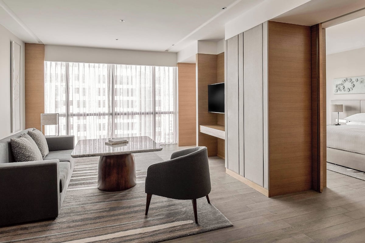 Une chambre d’hôtel moderne équipée d’un canapé, d’une table à manger, d’un téléviseur et d’un lit.