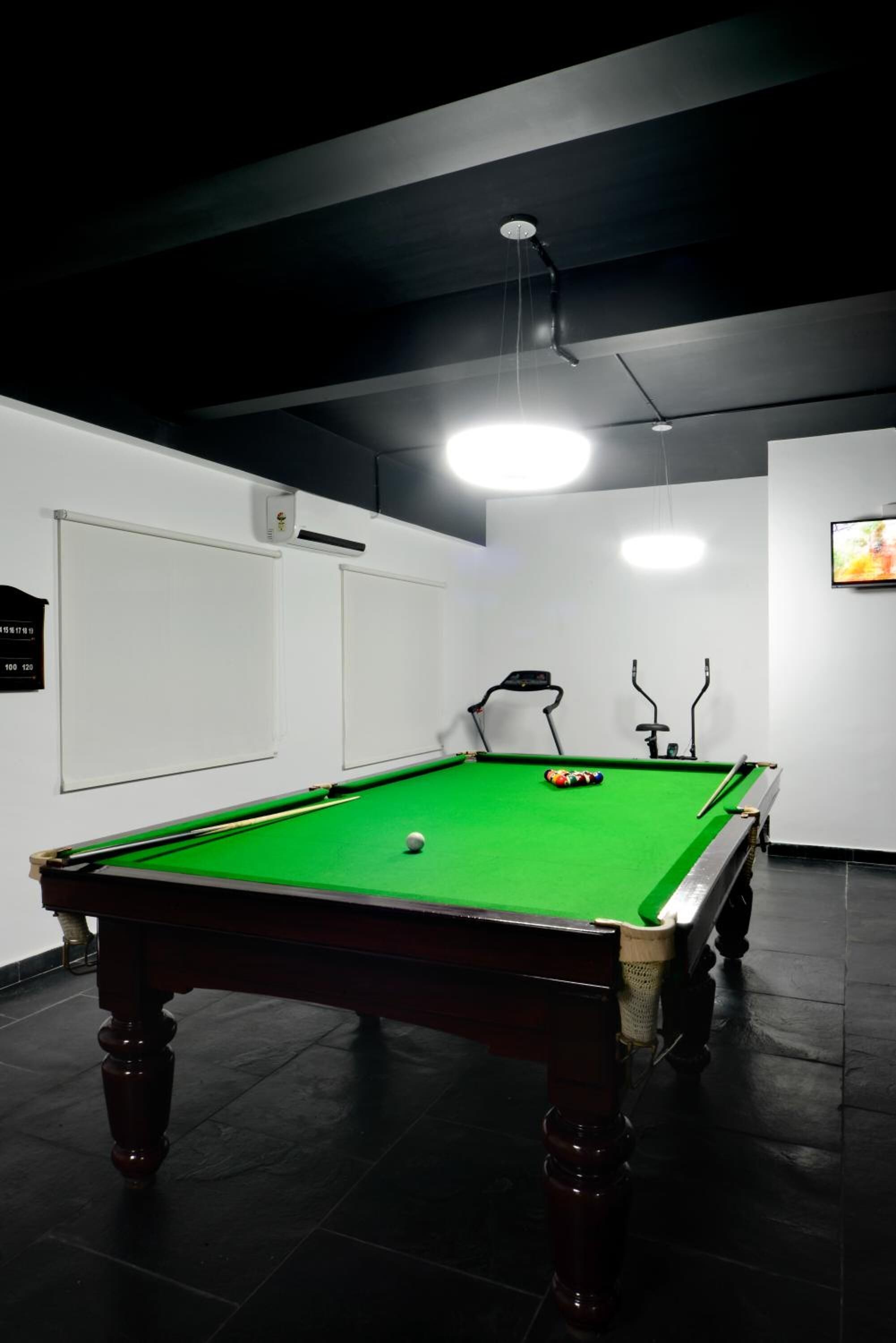A pool table with a green felt surface, a cue ball, and a set of pool cues.
