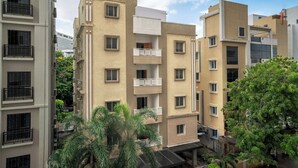 Um edifício residencial com várias andares, varandas, telhado plano e céu claro.