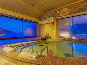 Una piscina cubierta climatizada con vistas a las montañas a través de grandes ventanales.