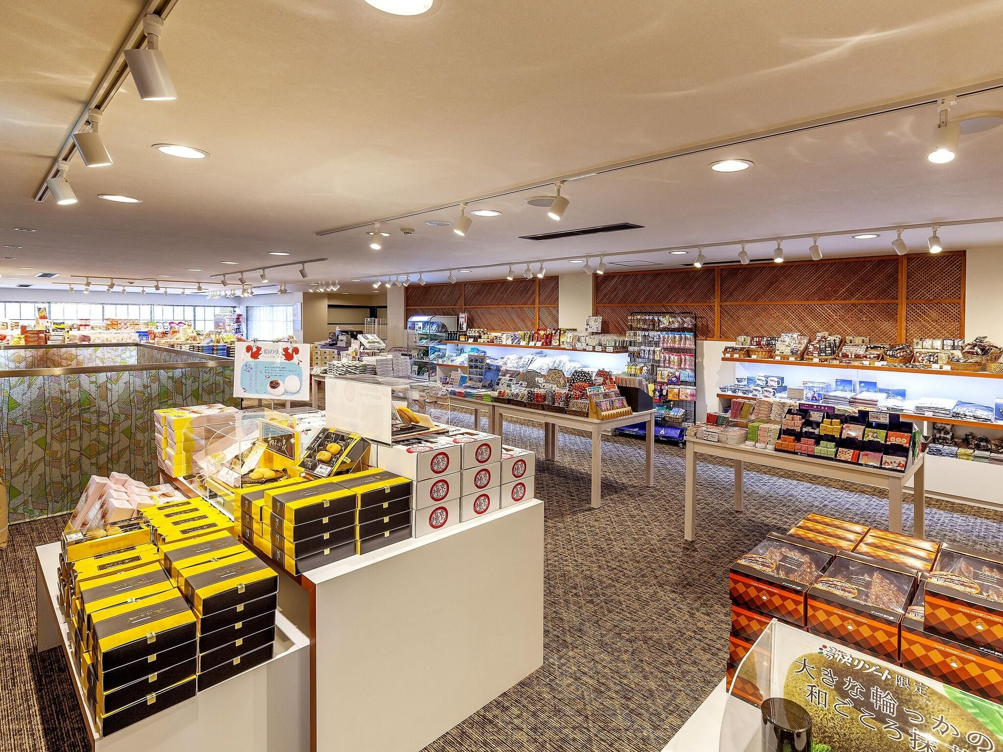 A well-lit retail store with various products on display, including boxed items and shelves with goods.