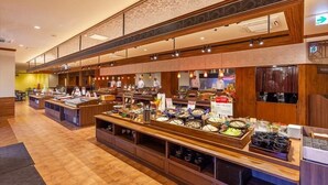 A buffet setup with multiple food stations and a kitchen area in the background. - Yukai Resort Unzen Onsen Unzen Toyokan (Unzen)