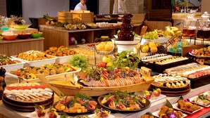 Un buffet con diversi piatti, tra cui sushi, insalate e frutti di mare.