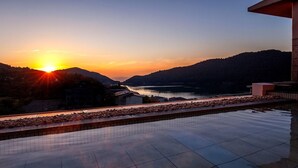 Una piscina sul tetto con vista su un tramonto sul lago e sulle colline.