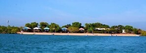 Propiedad frente a la playa con varias cabañas y una playa de arena.