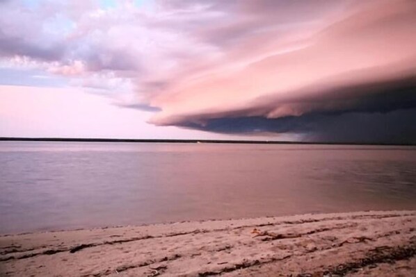 A beach with a calm sea and a cloudy sky. - Crab Claw Island (Bynoe)