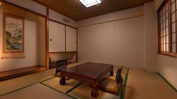 Ein traditioneller japanischer Raum mit Tatami-Böden, einem niedrigen Holztisch und Schiebetüren.