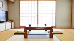 A traditional Japanese room with tatami flooring, a low wooden table, and sliding doors. - Kurashiki Seaside Hotel (Kurashiki)