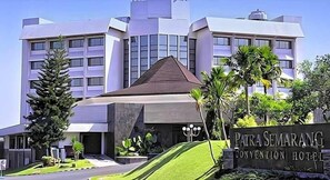 A modern building with a prominent sign for 'Pitra Semarang Convention Hotel.'