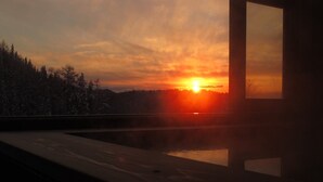 A sunset view from a balcony with a pool, surrounded by trees. - Hotel White Inn Kitashiga (Yamanouchi)