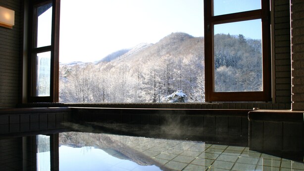 A room with a large window overlooking a snowy mountain landscape. - Hotel White Inn Kitashiga (Yamanouchi)