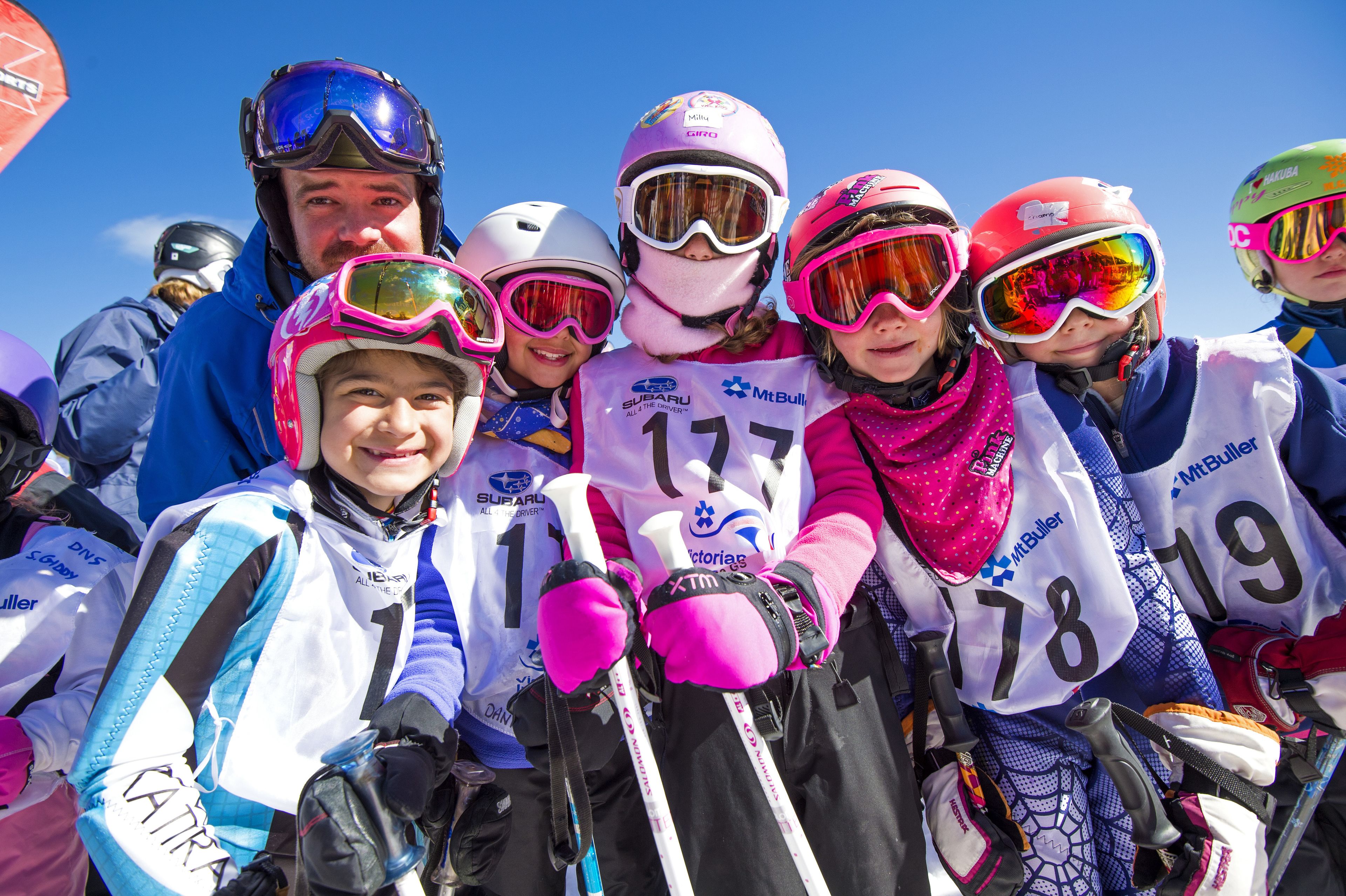 A group of people in ski gear with numbered bibs, indicating a skiing event or competition.